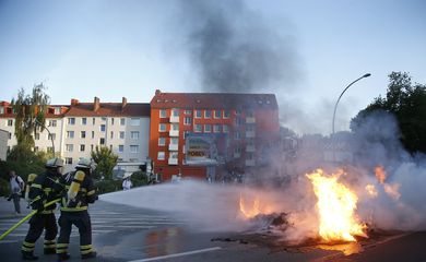 Bombeiros atuam no combate a incêndio em veículo provocado durante os protestos contra o G20 em Hamburgo