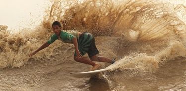 Surfista em onda de pororoca na cidade de Cutias, no Amapá