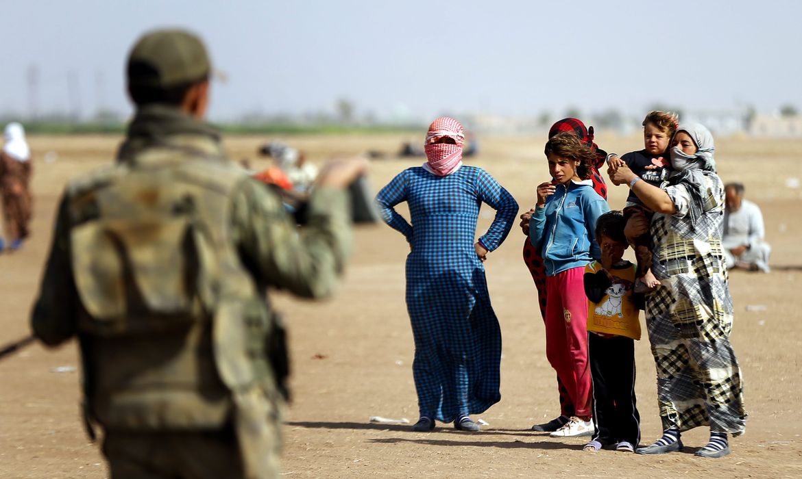 epa04414407 Syrian refugees wait at the Syrian-Turkish border near Sanliurfa, Turkey, 24 September 2014. The Islamic State assault against dozens of Kurdish villages in northern Syria could create a mass exodus, with up to 400,000 seeking refuge in neighbouring Turkey, a United Nations official warned. According to Turkish authorities, 138,000 Kurdish Syrians have poured into the country since late last week. It is unclear if the entire population of the region will ultimately end up fleeing, UN refugee agency (UNHCR) spokeswoman Melissa Fleming said.  EPA/SEDAT SUNA