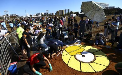 Fiéis confeccionam os tradicionais tapetes de serragem durante a Festa de Corpus Christi de Brasília, que retorna à Esplanada dos Ministérios após 2 anos de celebrações reduzidas por conta da pandemia.
