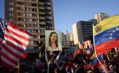Manifestante segura cartaz com a imagem da líder da oposição venezuelana María Corina Machado durante manifestação em Santiago
03/01/2026 REUTERS/Pablo Sanhueza