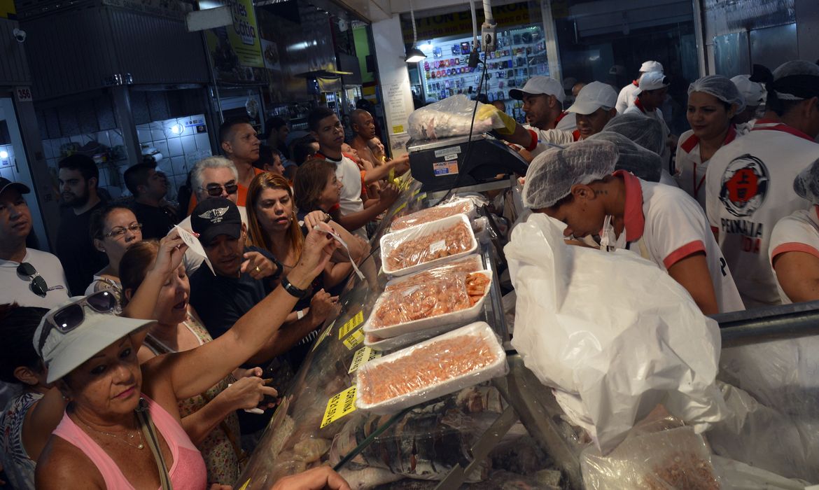 Brasília - O balcão da Peixaria Ueda, na Feira do Guará, estava lotado de consumidores que vieram comprar o tradicional pescado para a Sexta-feira Santa (José Cruz/Agência Brasil)