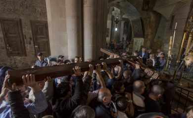 Cristãos carregam cruz de madeira na Igreja do Santo Sepulcro, em Jerusalém, durante procissão da Via Sacra na Sexta-feira Santa