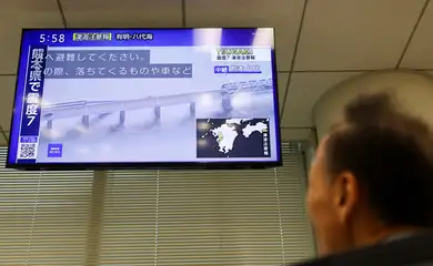 Tela de televisão exibindo imagens de uma ponte desabada após um terremoto com magnitude preliminar de 7,1 ter atingido a província de Kumamoto, no sul do Japão, em Tóquio, Japão, em 28 de julho de 2026
REUTERS/Issei Kato