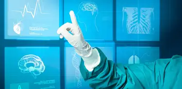 Close em mão de médico com luva apontando para paineis eletrônicos