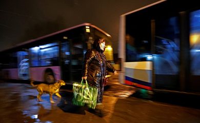 Mulher em Donetsk se prepara para entrar em ônibus para retirada da região