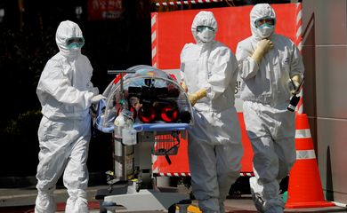 Medical workers carry a patient who was suspected of having coronavirus disease (COVID-19) in a Negative Pressure Isolation stretcher into a facility of Kyungpook National University Hospital in Daegu