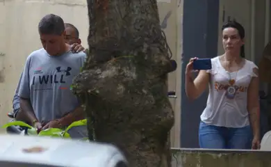 Ronnie Lessa, suspeito do assassinato da vereadora Marielle Franco, é escoltada por um policial quando ele deixa o departamento de homicídios para prestar depoimento na justiça Rio de Janeiro.