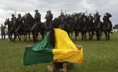 Brasilia 07/02/2023 - Manifestantes invadem predios publicos na praca dos Tres Poderes, na foto uma manifestante se ajoelha na frente da cavalaria montada da policia militar proximo predio do Tribunal Superior Federal (STF)
