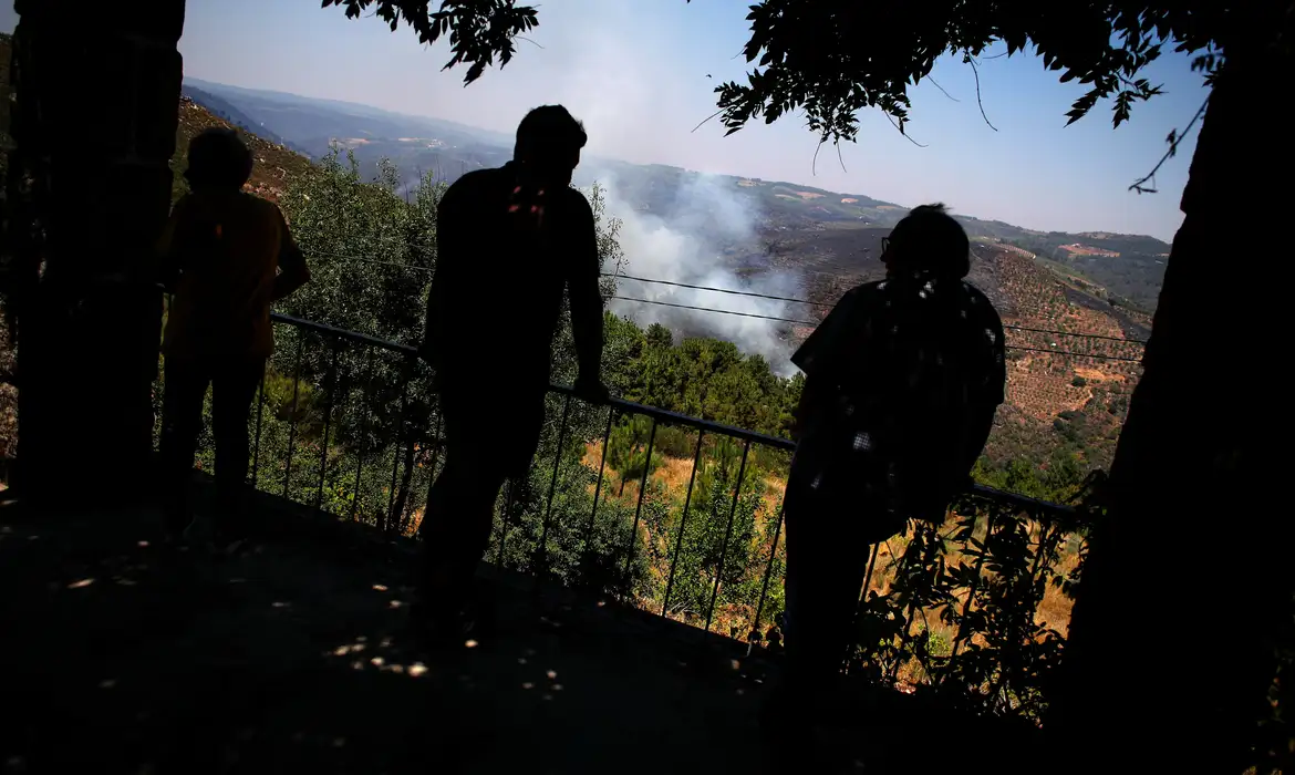 People watch a wildfire in Murca