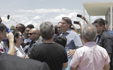 Presidente Jair Bolsonaro posa para fotos com populares na Praça dos Três Poderes, em Brasília