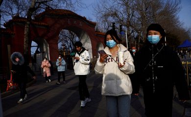 FILE PHOTO: People, wearing masks to prevent coronavirus disease (COVID-19), walk along the street in Beijing, China, February 14, 2023. REUTERS/Tingshu Wang/File Photo