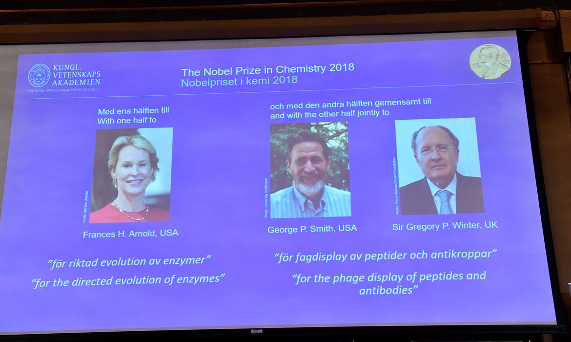 Pictures of the 2018 Nobel Prize laureates for chemistry: Frances H. Arnold of the United States, George P. Smith of the United States and Gregory P. Winter of Britain are displayed on a screen during the announcement at the Royal Swedish
