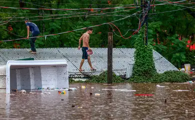 People walk on a roof in a flooded area next to the Taquari River during heavy rains in Encantado, Rio Grande do Sul state, Brazil, May 2, 2024. REUTERS/Diego Vara