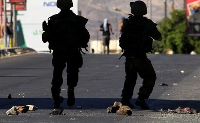 Soldados israelenses enfrentam manifestantes palestinos em protesto contra os ataques na Faixa de Gaza (Direitos Reservados/Alaa Badarneh/Agência Lusa) 