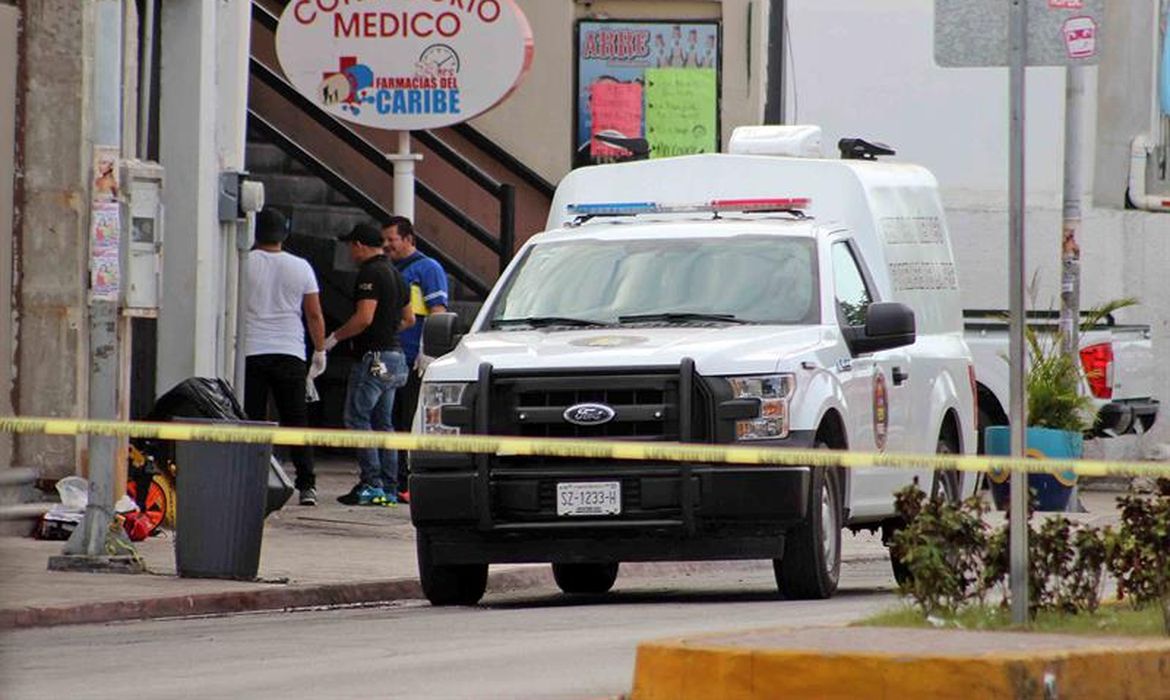 Peritos forenses trabalham na área onde um jornalista foi assassinado. O repórter levou ao menos dois tiros e morreu na hora 