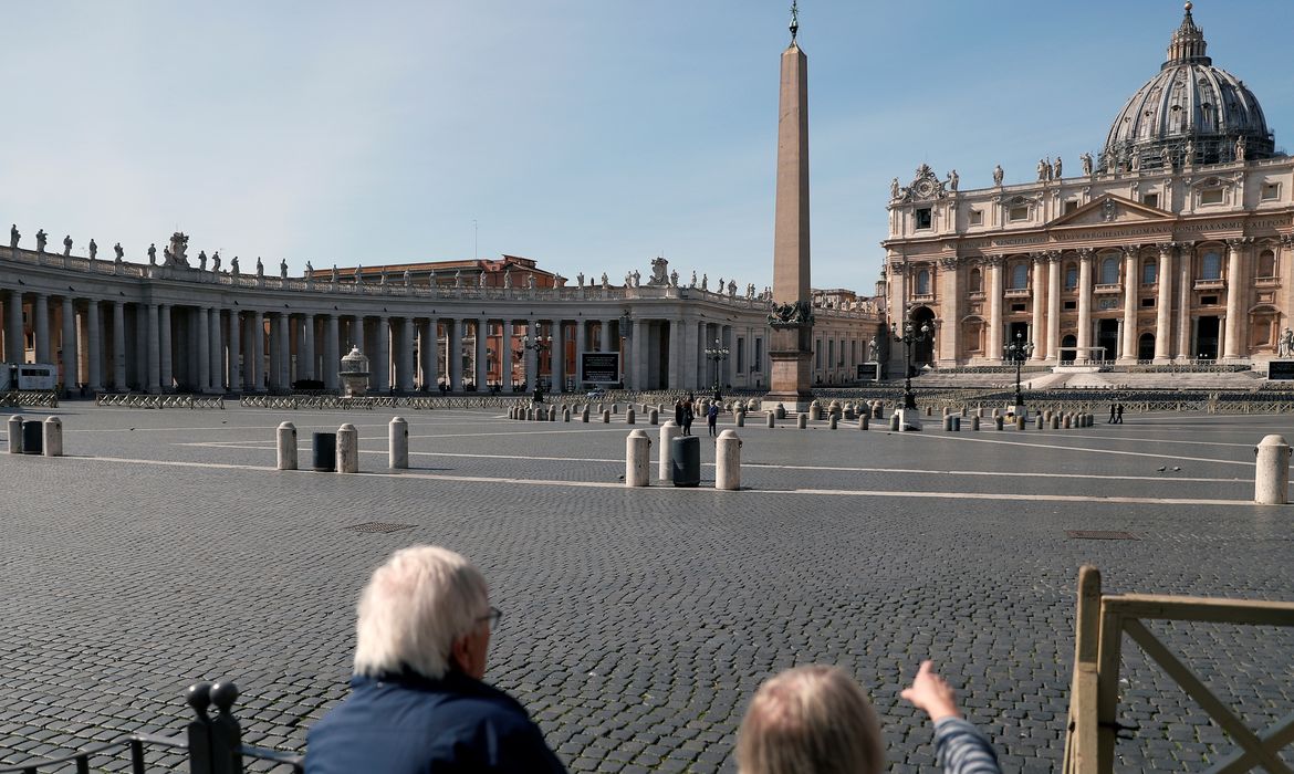A couple look at deserted St. Peter's Square after a decree orders for the whole of Italy to be on lockdown in an unprecedented clampdown aimed at beating the coronavirus, in Rome