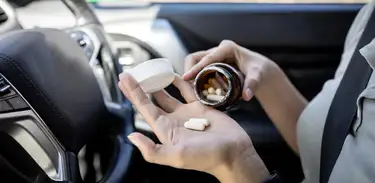Mulher toma comprimidos ao volante