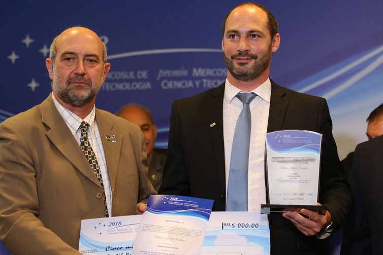 O presidente do CNPq, João Luiz Filgueiras de Azevedo, entrega o prêmio na categoria Jovem Pesquisador a Thiago Gentil Ramires, durante cerimônia de entrega do Prêmio Mercosul de Ciência e Tecnologia 2018