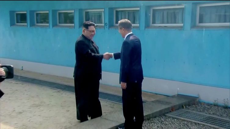 O líder norte-coreano Kim Jong-un cumprimenta o presidente sul-coreano Moon Jae-in na fronteira entre os dois países.
