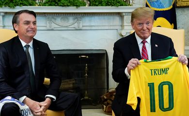 O presidente do Brasil, Jair Bolsonaro, dá uma camiseta da Seleção Brasileira de futebol para o presidente dos EUA, Donald Trump, durante reunião no Salão Oval da Casa Branca, em Washington (EUA). 