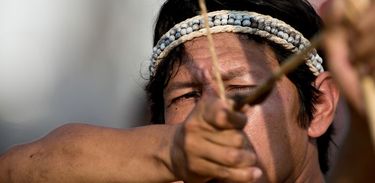 Close na mão de índio enquanto pratica arco e flecha
