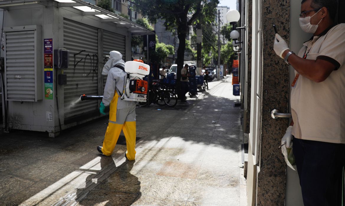 Agente de limpeza desinfecta rua em Niteróis (RJ)