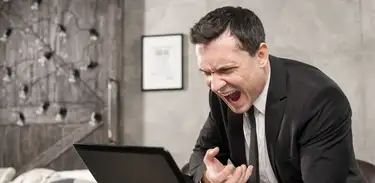 Homem com raiva grita para tela do computador