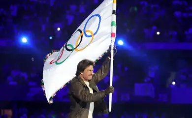 Paris 2024 Olympics - Ceremonies - Paris 2024 Closing Ceremony - Stade de France, Saint-Denis, France - August 11, 2024. Actor Tom Cruise holds the Olympic flag during the closing ceremony. REUTERS/Phil Noble