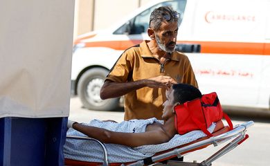 Um homem está ao lado de um palestino ferido, que receberá tratamento em um hospital egípcio, no posto fronteiriço de Rafah com o Egito, no sul da Faixa de Gaza, em 1º de novembro de 2023. REUTERS/Ibraheem Abu Mustafa TPX IMAGENS DO DIA