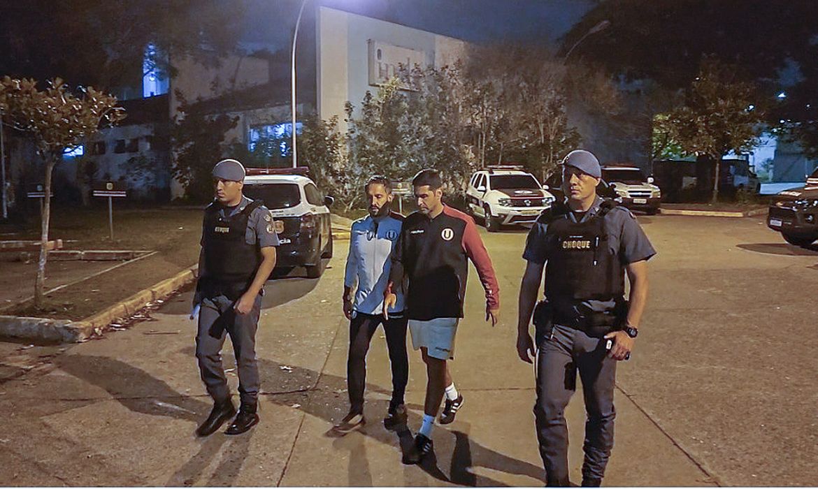 Sebastian Avellino Vargas, preparador físico do Universitario (Peru) - homem de casaco na foto -  é preso após fazer gestos racistas contra torcida do Corinthians após derrota nos playoffs da Sul-Amrericana - racismo - em 11/07/2023