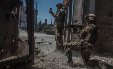 Soldado ucraniano observa enquanto tanque dispara na direção de tropas russas em área industrial da cidade de Sievierodonetsk, na Ucrãnia