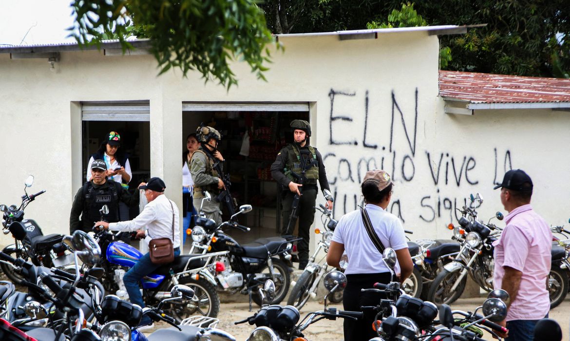 Colombian security forces stand guard as members of a humanitarian caravan comprising senators and social organisations, meet with residents, to demand ceasefire and peace in the Catatumbo region, after attacks by rebels from the leftist National Liberation Army (ELN), in the municipality of El Tarra, Colombia February 4, 2025. REUTERS/Carlos Eduardo Ramirez