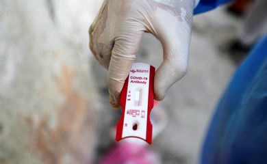 A healthcare worker shows a blood sample during testing for the coronavirus disease (COVID-19) in Sadr city, district of Baghdad