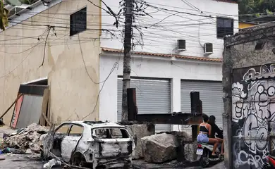 Rio de Janeiro (RJ), 30/10/2025 – Pessoas passam em moto na praça da Vila Cruzeiro ao lado de barricadas que foram colocadas para conter avanço de policiais durante a Operação Contenção. Foto: Tânia Rêgo/Agência Brasil