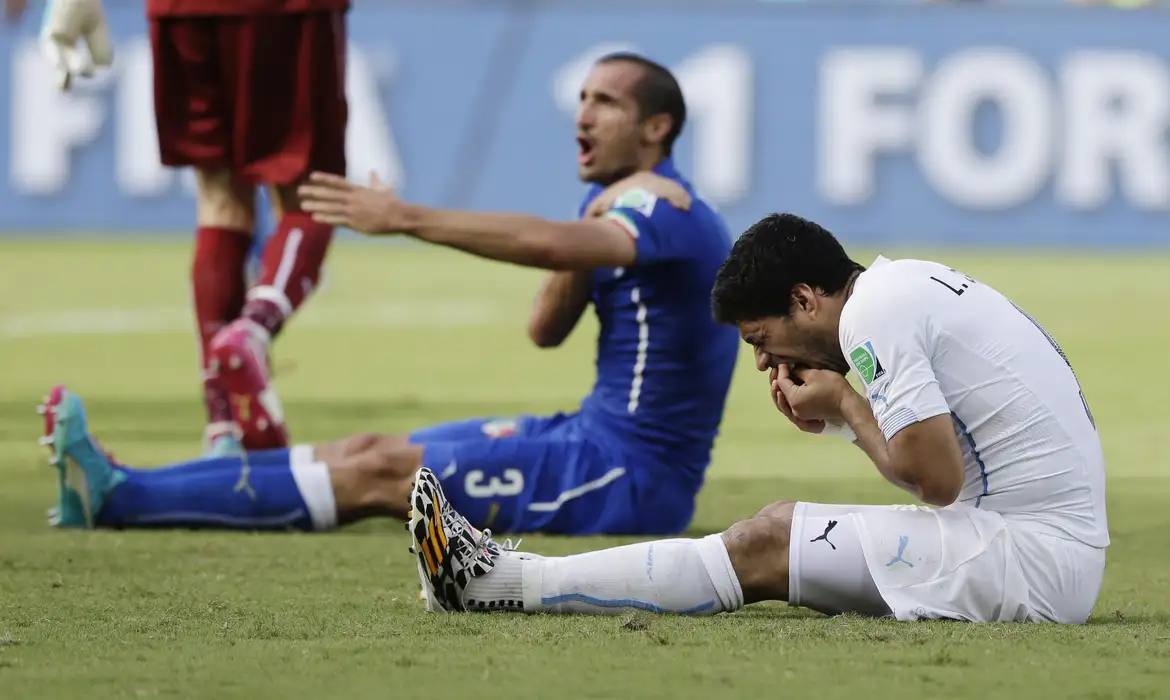 Italy's Giorgio Chiellini complains after Uruguay's Luis Suarez ran into his shoulder with his teeth during the group D World Cup soccer match between Italy and Uruguay at the Arena das Dunas in Natal, Brazil, Tuesday, 