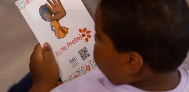 Criança lendo sobre cartilha de proteção 