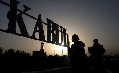 FILE PHOTO: Taliban soldiers stand in front of a sign at the international airport in Kabul