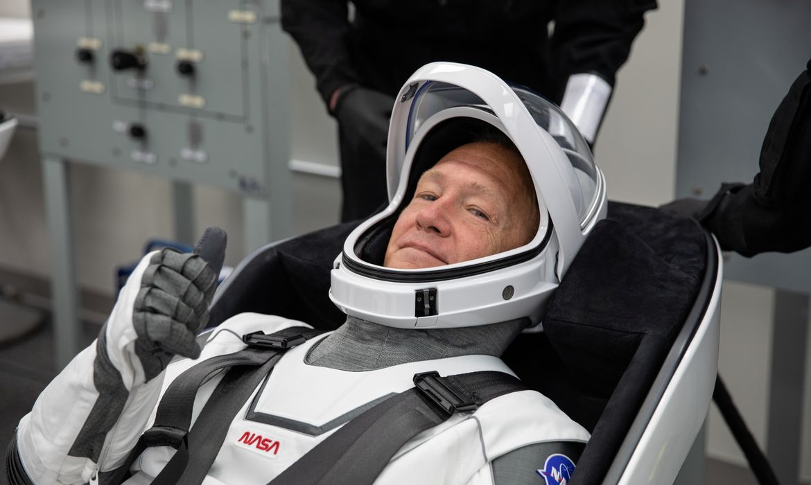 NASA astronaut Douglas Hurley rehearses putting on his SpaceX spacesuit in the Astronaut Crew Quarters