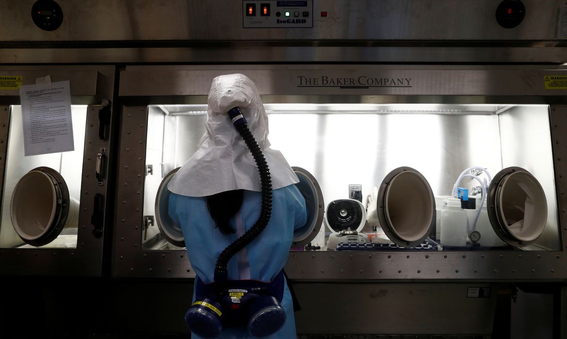 Um cientista da Agência de Ciência e Tecnologia da Equipe Doméstica (HTX) demonstra, sem uma amostra viva, o processo de extração do kit de teste de coronavírus em seu laboratório em Cingapura, em 5 de março de 2020. Esses kits de teste, uma