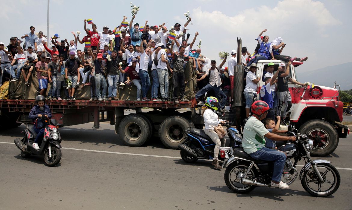 Partidários da oposição venezuelana acenam de um caminhão transportando ajuda humanitária para a Venezuela, perto da fronteira, nos arredores de Cucuta, Colômbia