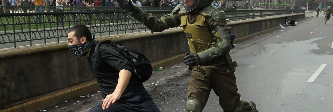 Carabinero corre atrás manifestante durante protesto no Chile