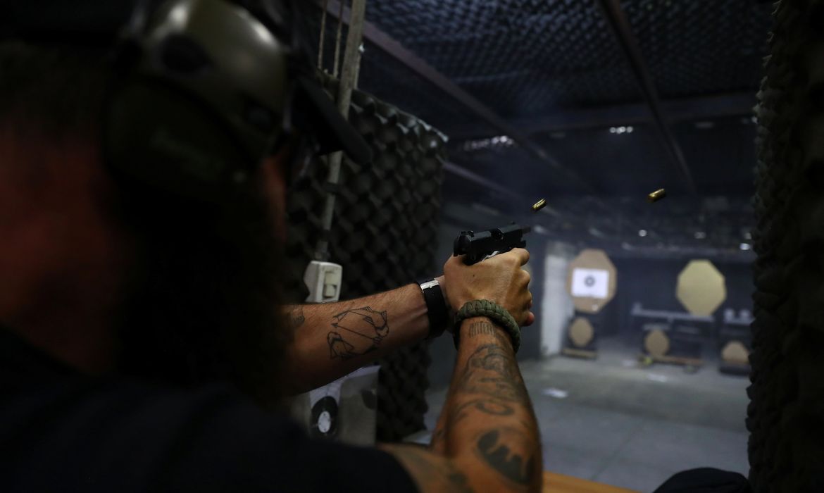 Joao Bercle, instructor of the Colt 45 shooting club, fires a gun, in Rio de Janeiro