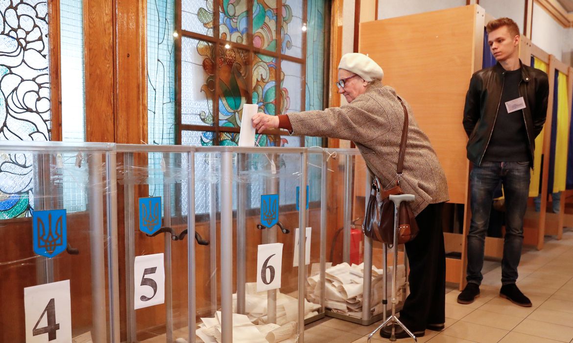 Uma mulher coloca sua cédula em uma estação de votação durante eleição presidencial em Kiev, na Ucrânia