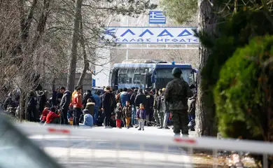 A group of migrants walk through the Turkish-Greek border in a village near the border city of Edirne