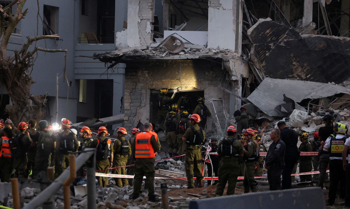 Emergency personnel work at an impact site following a missile attack from Iran on Israel, in Tel Aviv, Israel, June 16, 2025. REUTERS/Ronen Zvulun