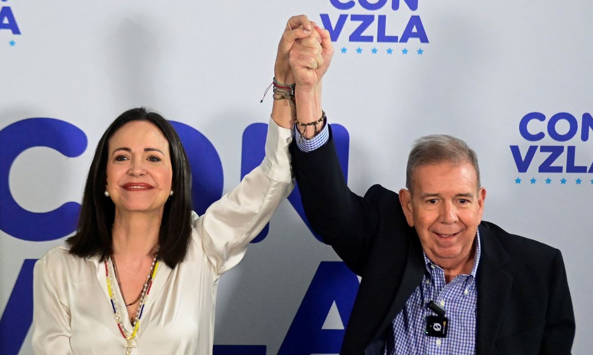 Venezuelan opposition leader Maria Corina Machado and opposition presidential candidate Edmundo Gonzalez raise their hands during a press conference following the announcement by the National Electoral Council that Venezuela's President Nicolas Maduro won the presidential election, in Caracas, Venezuela, July 29, 2024. REUTERS/Maxwell Briceno