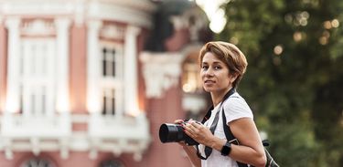 Mulher com máquina fotográfica em uma cidade histórica