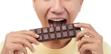 Homem morde barra de chocolate