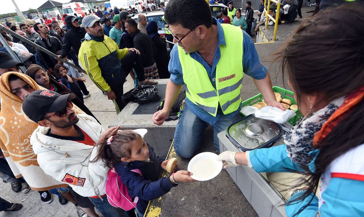 Refugiados provenientes da Hungria recebem doações de refeições na Áustria (Agência Lusa/Direitos Reservados)